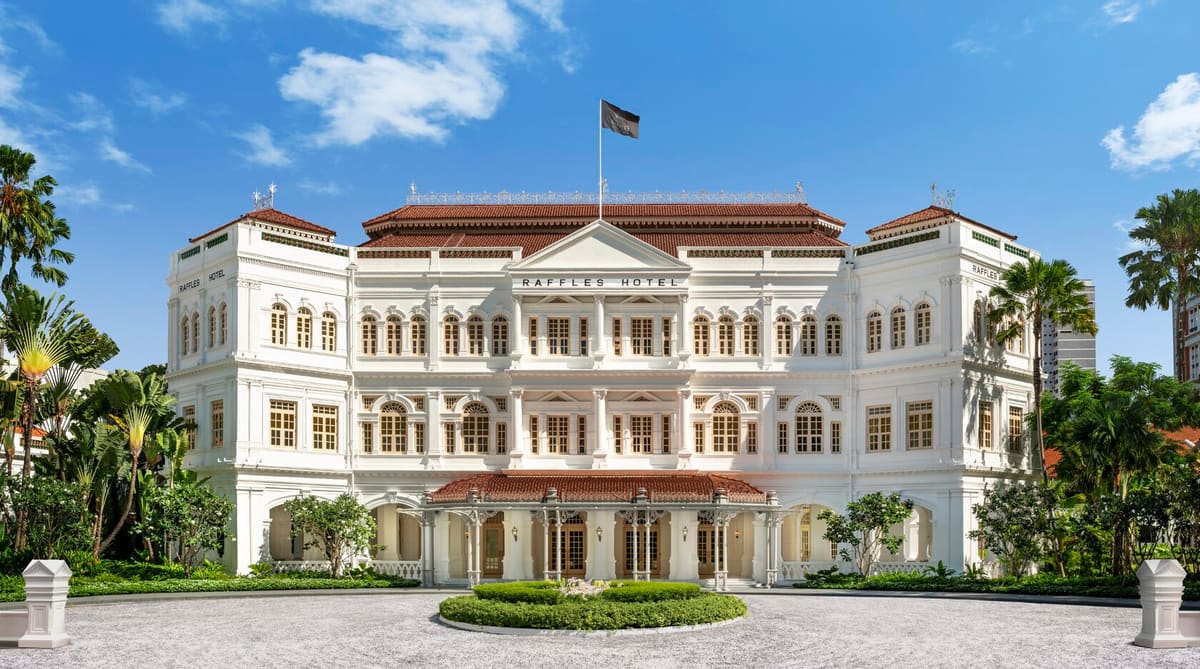 Historic hotel with a white colonial façade and palm trees, Singapore